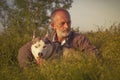 Old man with his dog in a field at sunset Royalty Free Stock Photo