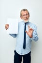 old man holding documents with a sheet of paper light background Royalty Free Stock Photo