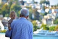 An old man holds a baby tenderly on boat trip from Interlaken West heading toward Thun City, Switzerland. Royalty Free Stock Photo