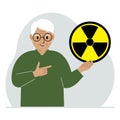 A old man holds a sign with a warning about nuclear danger. The concept of nuclear war, radiation, biohazard.