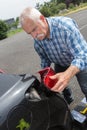 Old man installs tail light on vehicle Royalty Free Stock Photo