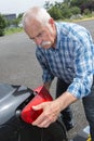 Old man installs tail light on vehicle Royalty Free Stock Photo