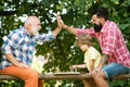 Old man with little boy playing chess. Cute little boy playing chess with Parents. Grandfather and father playing chess