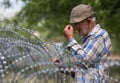 Old man on local stand near barbed wire
