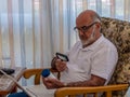 Old man with magnifying glass reading on the jar with vitamines