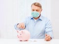 Old man in mask putting coin into big piggy bank Royalty Free Stock Photo