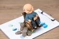 Old man model and coins on financial documents