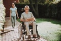 Old Man and Nurse Walk Together. Aged and Stroller