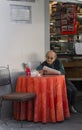 Old man in outdoor cafes, reading the newspaper, October 22, 2014, Lucca, Italy Royalty Free Stock Photo