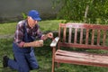 Old man painting bench in garden Royalty Free Stock Photo