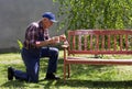 Old man painting bench in garden Royalty Free Stock Photo