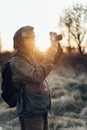 Old man photographer standing in autumn park and taking pictures with camera Royalty Free Stock Photo