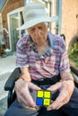 Old man playing a cube puzzle to help with brain injury and bleed.Hampshire,England,United Kingdom
