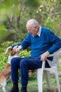 Old man playing with dog in garden