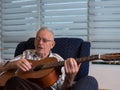 Old man playing guitar at home Royalty Free Stock Photo