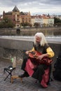 Old man playing music instrument Pin Harp for show Czechia people and foreigner travelers at Charles Bridge crossing Vltava river Royalty Free Stock Photo