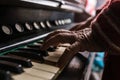 Old man playing the piano in a close up view of his wrinkled han