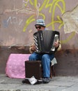 Old man playing piano accordion for money.