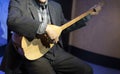 An old man playing Turkish musical instrument baglama in local clothes. Baglama is the most commonly used string folk instrument