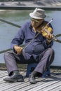 Old man playing violin at Pont des Arts - The Love Lock Bridge. Royalty Free Stock Photo