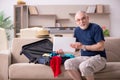 Old man preparing for trip at home