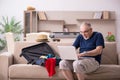 Old man preparing for trip at home