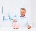 Old man putting coin into big piggy bank Royalty Free Stock Photo