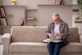 Old man reading book at home Royalty Free Stock Photo