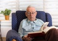 Old man reading book at home Royalty Free Stock Photo