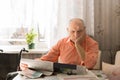 Old Man Reading Newspaper with Hand on Face Royalty Free Stock Photo