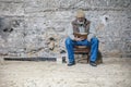 Old man reads a book, sits on an old chair, reads a book Royalty Free Stock Photo