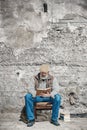 Old man reads a book, sits on an old chair, reads a book Royalty Free Stock Photo