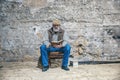 Old man reads a book, sits on an old chair, reads a book Royalty Free Stock Photo