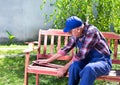 Old man repairing bench in garden