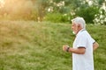 Old man running in city park on sunset. Royalty Free Stock Photo