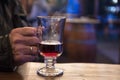 Old man`s hand holding a glass with mulled wine at the christmas Royalty Free Stock Photo
