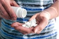 The old man`s hands are pouring pills from a white bottle into his hand. Medical concept. Close-up Royalty Free Stock Photo