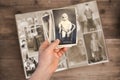 Old manÃ¢â¬â¢s male hands hold old retro family photos over an album with vintage monochrome photographs in sepia color, the concept Royalty Free Stock Photo