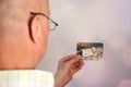 Old manÃ¢â¬â¢s male hands hold old retro family photos in sepia color, genealogy concept, ancestral memory, family ties, childhood