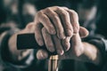 Old man`s wrinkled hand with a walking cane. Toned Royalty Free Stock Photo