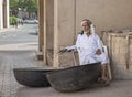 Old man selling old copper cooking dishes