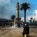 an old man selling Pigeon food mixture in the historic izmir clock tower ( saat kulesi square ) in izmir , turkey