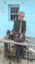 Old man in sewing machine. Royalty Free Stock Photo