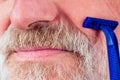 Old man shaver gray-haired beard blue disposable razor in studio white background Royalty Free Stock Photo