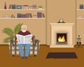 Old man is sitting in an armchair and reading a newspaper Royalty Free Stock Photo