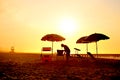 Old man sitting on the morning beach under summer umbrella Royalty Free Stock Photo