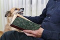 Old man sitting on the sofa with his lovely dog and book Royalty Free Stock Photo