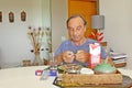 Old man sitting on the table taking a pill from the medicine tablet Royalty Free Stock Photo