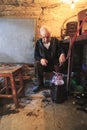 Old man stands in the old wine cellar and extracts the wine in b Royalty Free Stock Photo