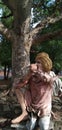 Old man statue sitting under a tree and smoking! Royalty Free Stock Photo